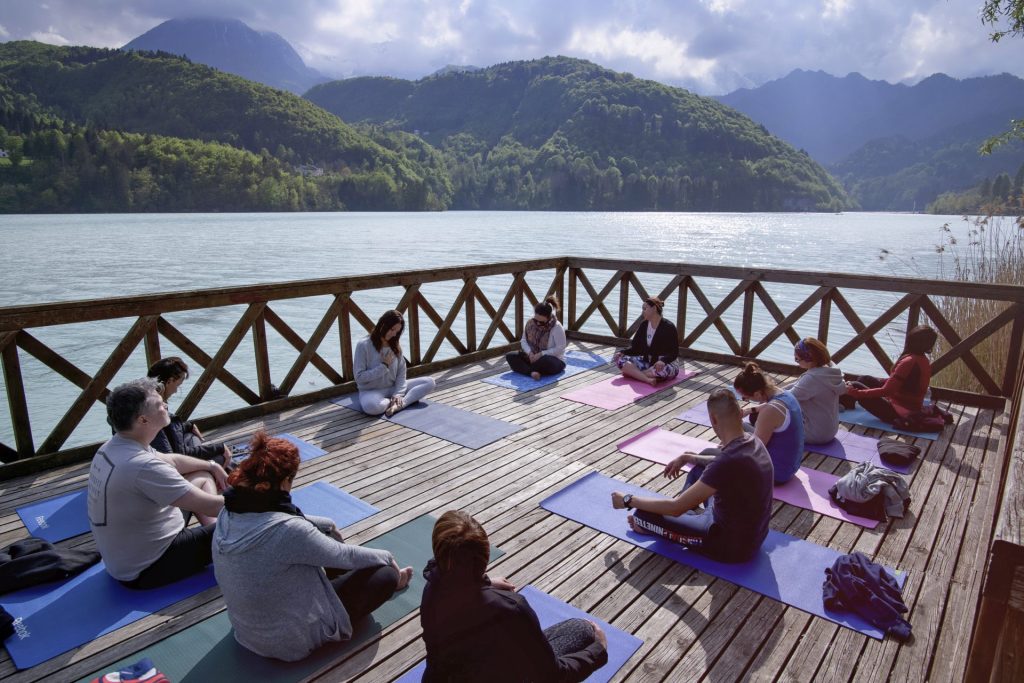 Group of people sitting on their yoga mats preparing for an embodiment practice.